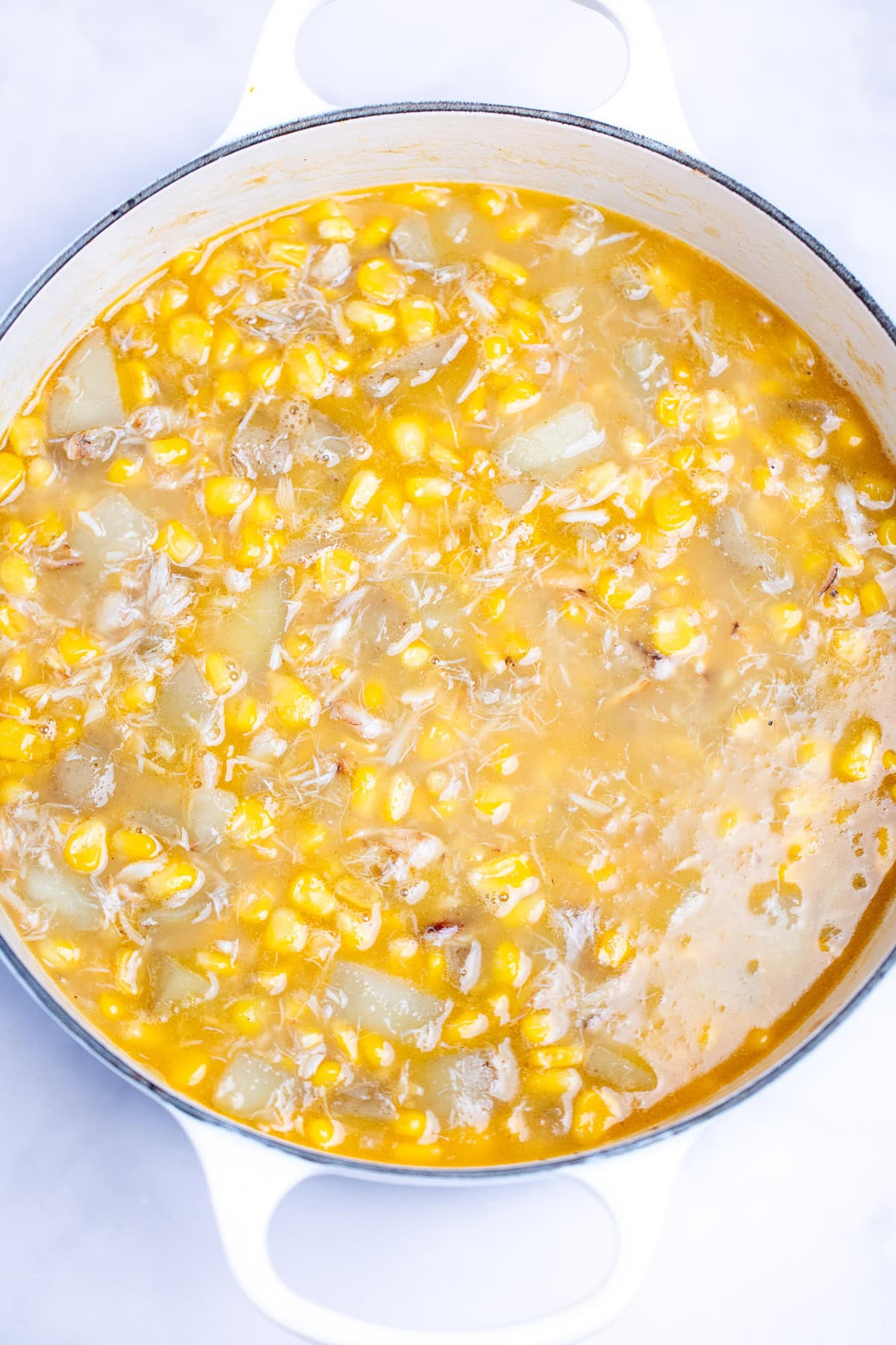 A dutch oven with crab and corn chowder before being pureed.