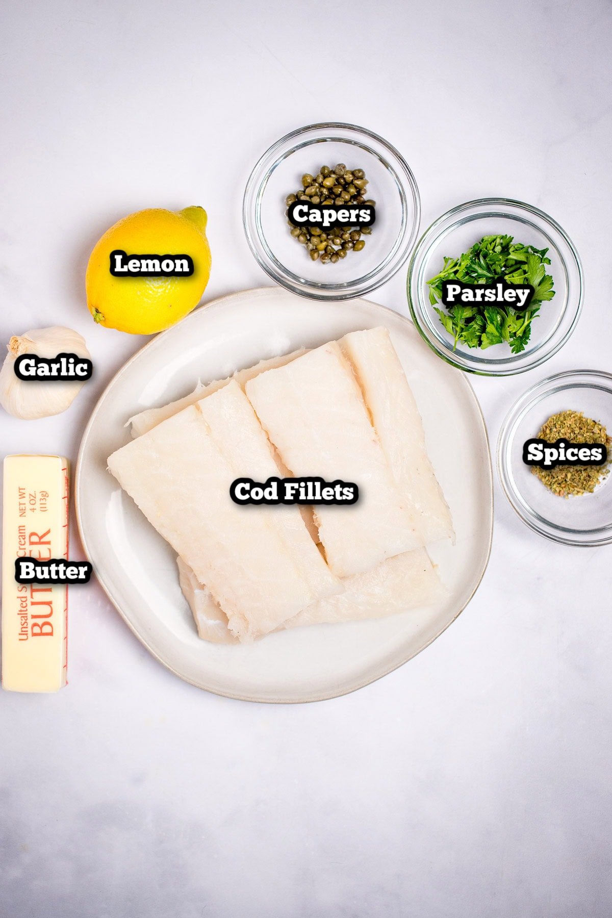 Individual ingredients for lemon butter baked cod on a table.