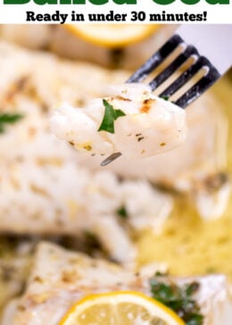 Pinterest pin with a baking dish with four cooked cod fillets, topped with lemon slices and fresh parsley, and in a lemon butter sauce. A fork is lifting up a piece of cod.