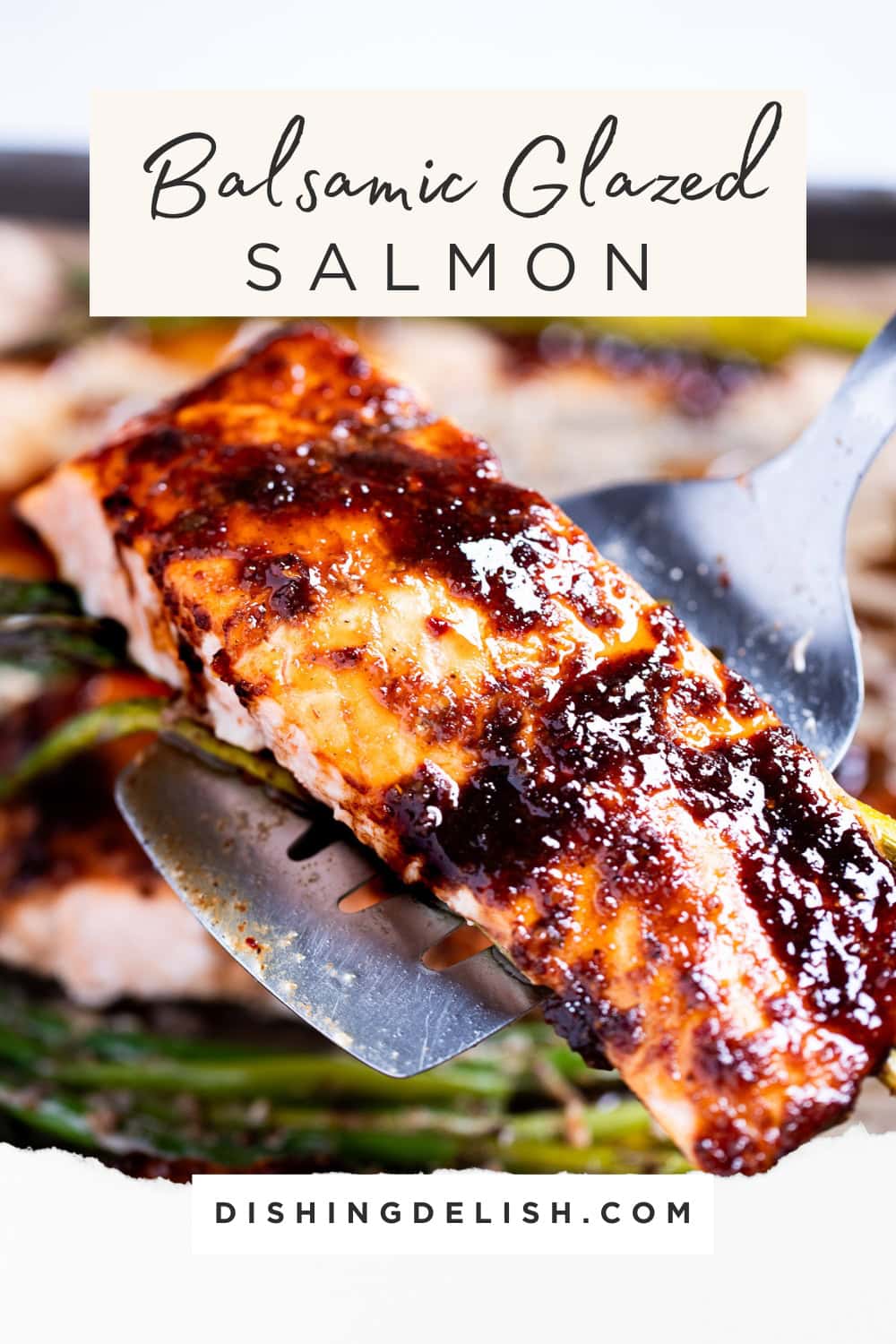 Pinterest pin with a spatula holding a balsamic glazed salmon fillet over a sheet pan with salmon and asparagus.