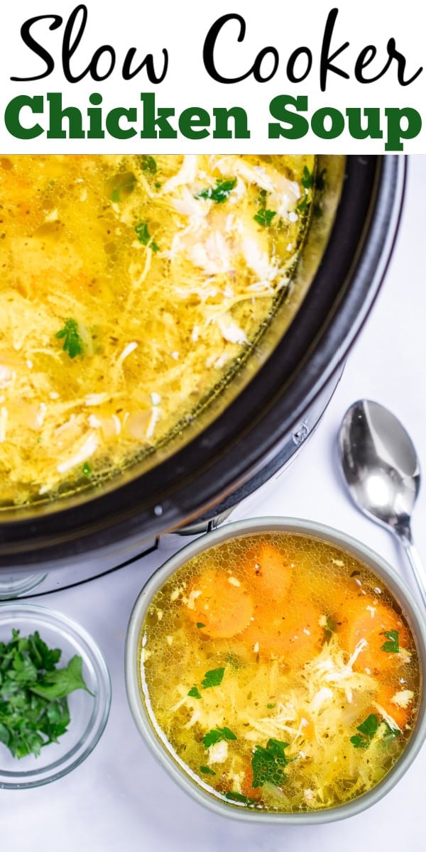 Pinterest pin with a bowl of chicken soup on a table, next to a smaller bowl of fresh parsley to the left and a spoon on the table to the right, in front of a slow cooker of soup.