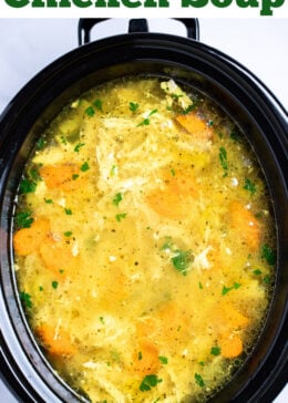 Pinterest pin with a slow cooker full of chicken soup topped with fresh parsley on a table.