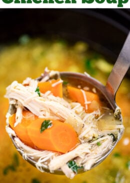 Pinterest pin with a ladle lifting chicken soup out of the slow cooker with pieces of chicken, broth, and carrots in it.