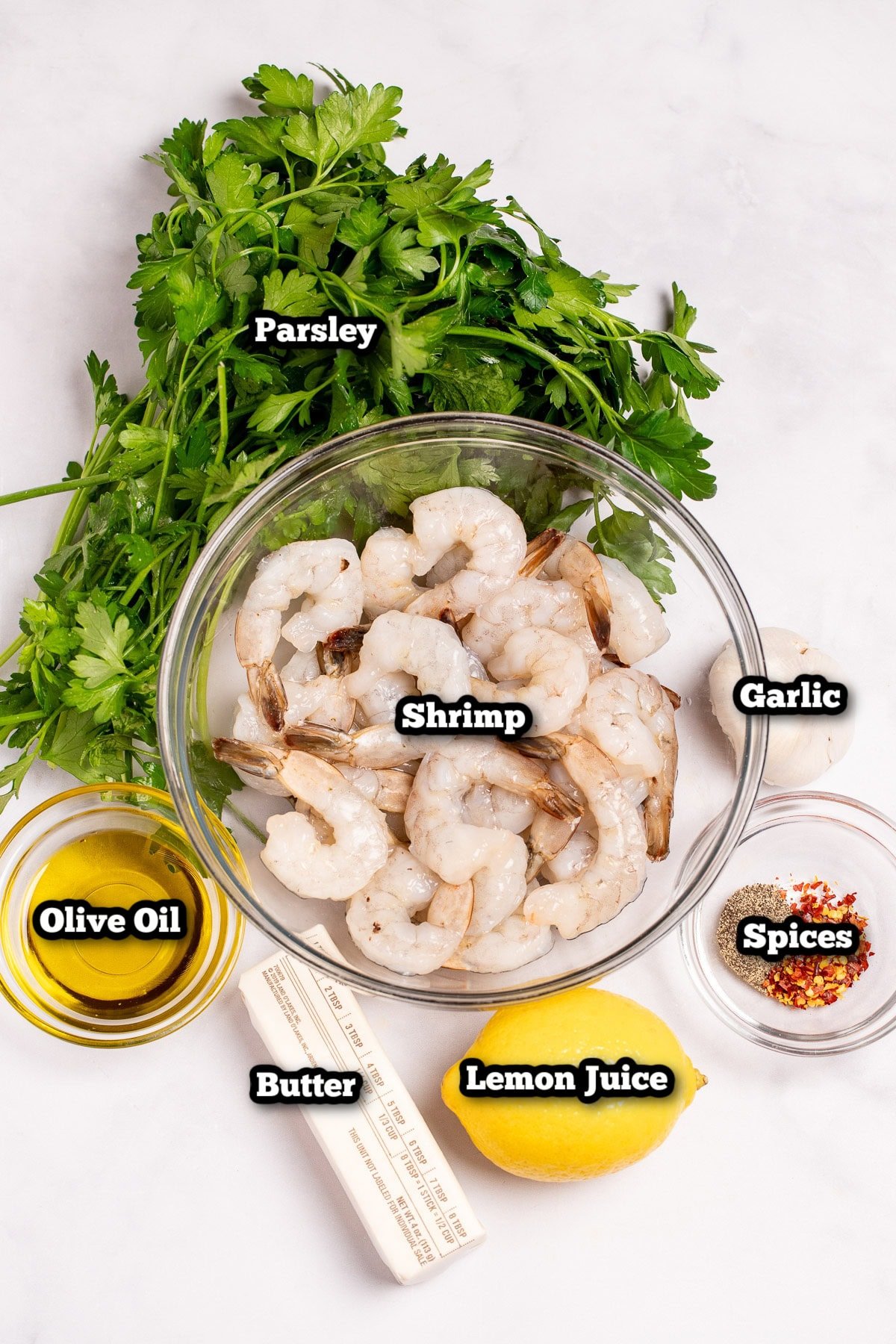 Individual ingredients for garlic butter shrimp scampi on a table.