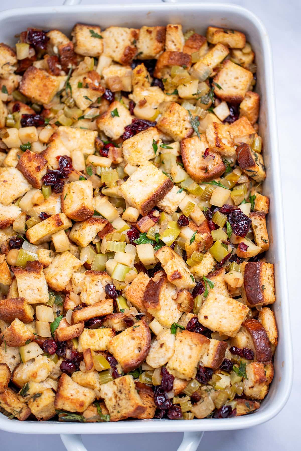 A baking dish full of gluten free stuffing on a table.