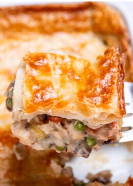 Pinterest pin with a baking dish with leftover turkey pot pie casserole with a flakey puff pastry crust, and a spatula lifting some up.
