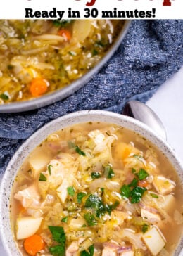 Pinterest pin with a bowl of turkey soup topped with fresh parsley next to a spoon and a kitchen towel on a table, with a dutch oven of soup in the background.