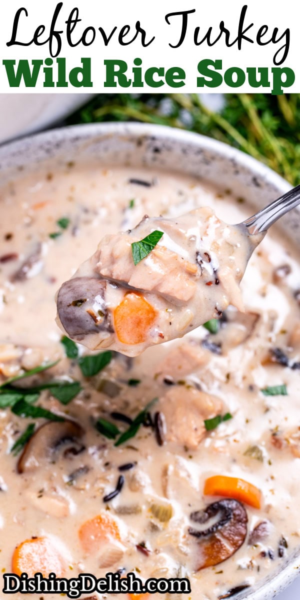 A bowl of turkey wild rice soup with a spoon lifting some out of the bowl.