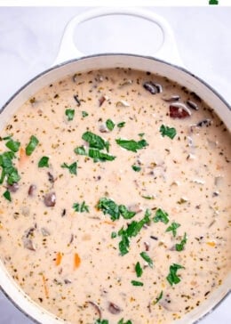 Pinterest pin with delicious homemade creamy leftover turkey and wild rice soup garnished with fresh parsley in a dutch oven.