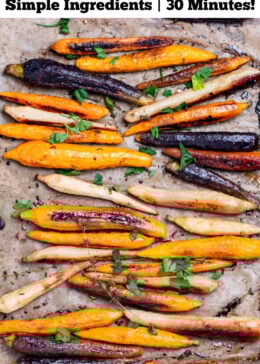 Pinterest pin with a sheet pan lined with parchment paper with roasted and caramelized rainbow carrots in a single layer, with sprigs of fresh thyme, after being roasted.