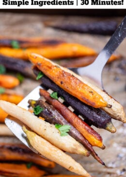 Pinterest pin with a spatula lifting roasted rainbow carrots from a sheet pan lined with parchment paper.