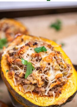 Pinterest pin with a sheet pan lined with parchment paper with halves of acorn squash stuffed with ground sausage and vegetables and topped with melted mozzarella and fresh parsley, with a spatula lifting one up.