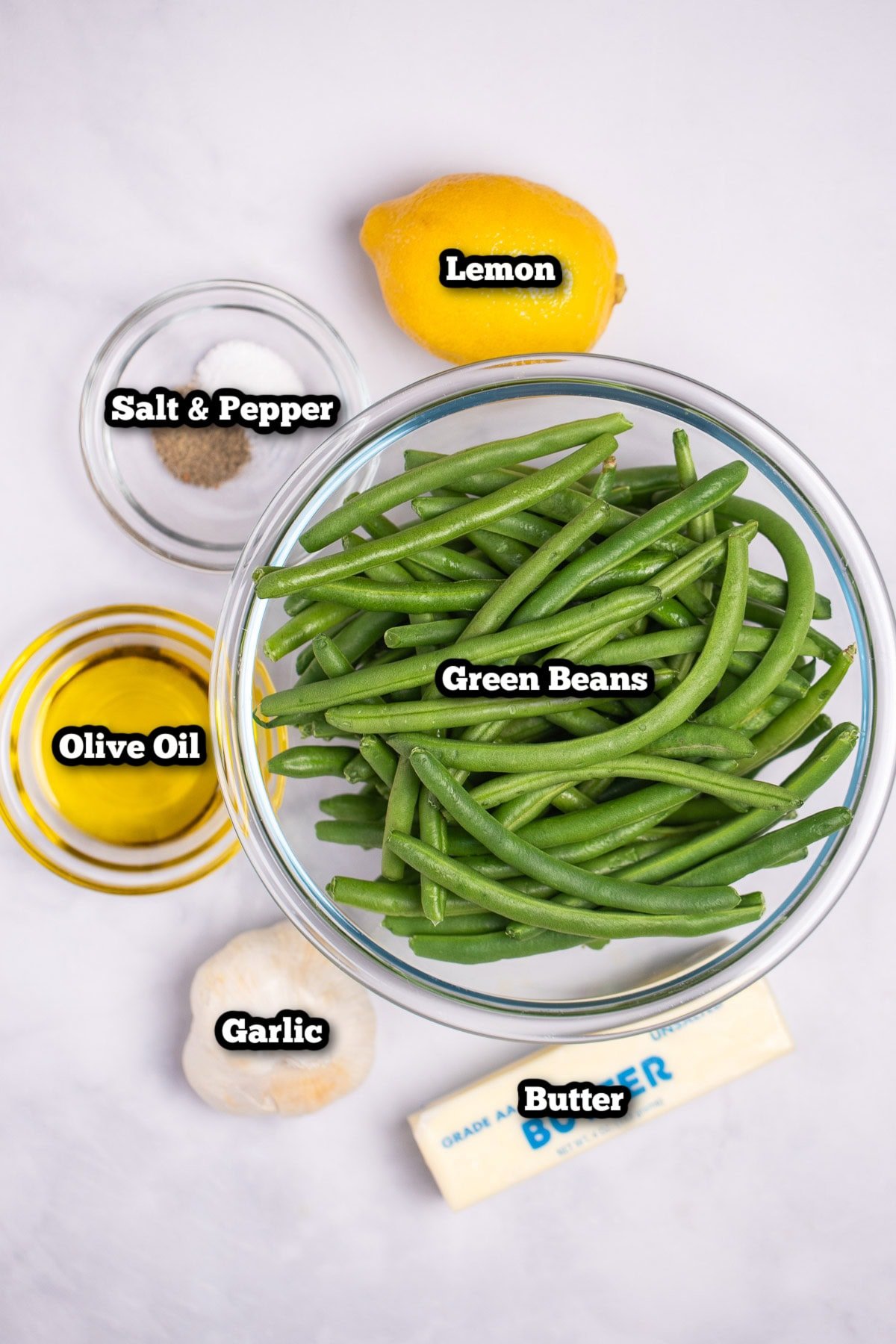 Individual ingredients for sautéed green beans with garlic on a table.