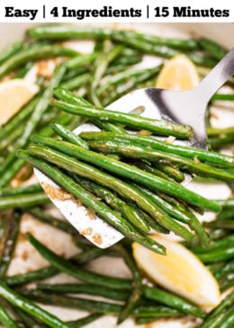 Pinterest pin with a sauté pan with cooked green beans with olive oil, salt, and pepper, and three lemon wedges resting on top, and a spatula lifting up some green beans.