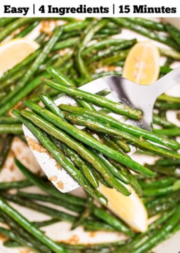 Pinterest pin with a sauté pan with cooked green beans with olive oil, salt, and pepper, and three lemon wedges resting on top, and a spatula lifting up some green beans.