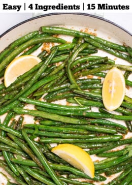 Pinterest pin with a sauté pan with cooked green beans with olive oil, salt, and pepper, and three lemon wedges resting on top.