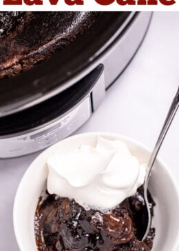 Pinterest pin with a bowl of chocolate lava cake topped with whipped cream and a spoon, in front of a slow cooker on a table.