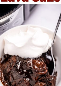 Pinterest pin with a bowl of chocolate lava cake topped with whipped cream and a spoon, in front of a slow cooker on a table.