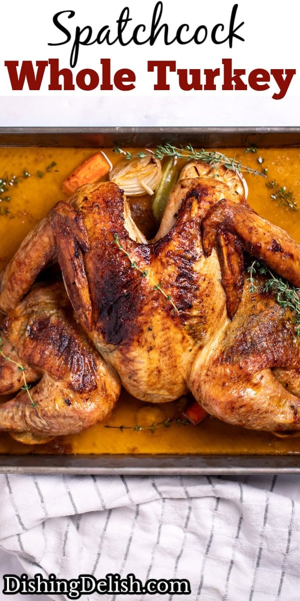 Pinterest pin with a roasting pan with a golden brown spatchcocked turkey resting on top of lemon and vegetables, with melted butter and fresh thyme on the bottom of the pan, and a kitchen towel on the table next to the roasting pan.