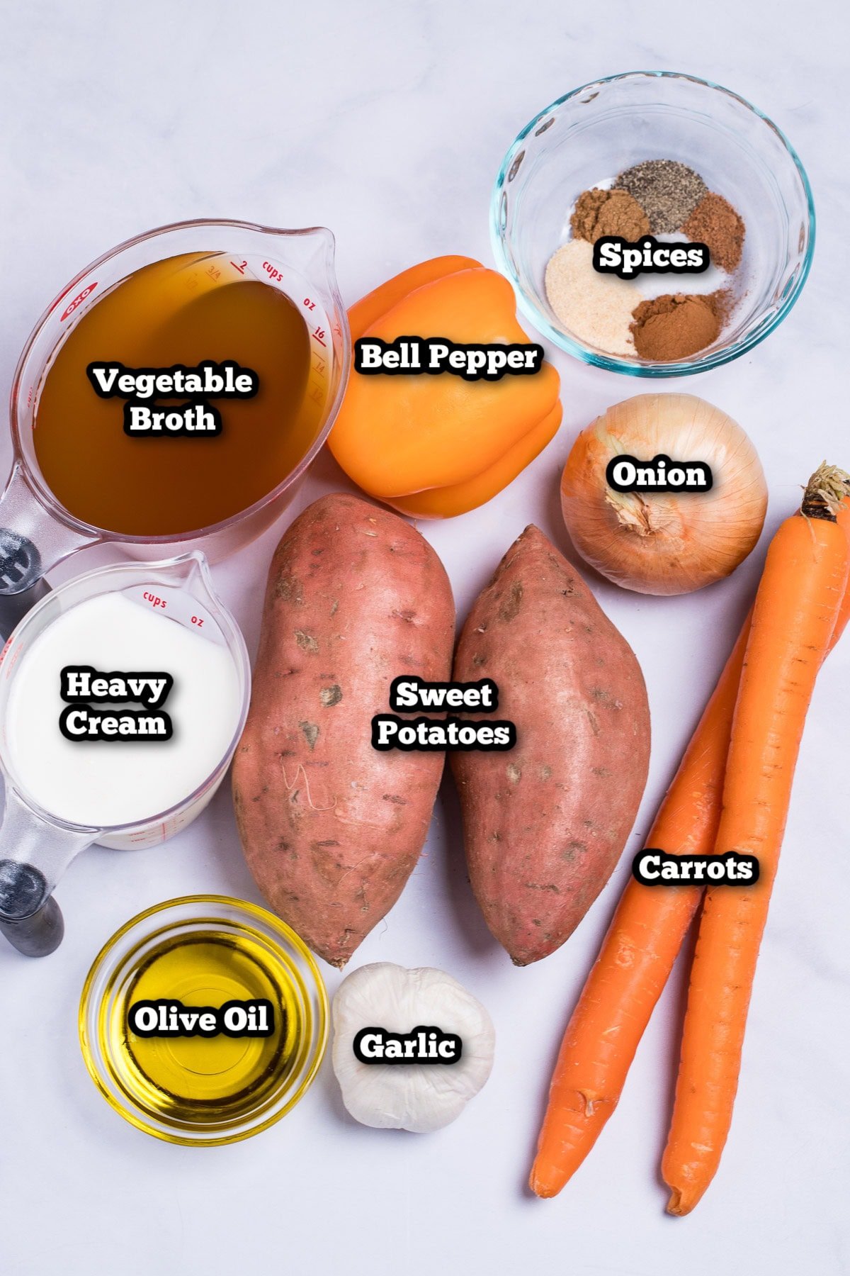 Individual ingredients for sweet potato soup on a table.