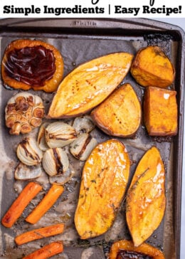 Pinterest pin with a sheet pan lined with parchment paper with fully roasted sweet potato halves, carrots, bell peppers, onion, and a bulb of garlic.