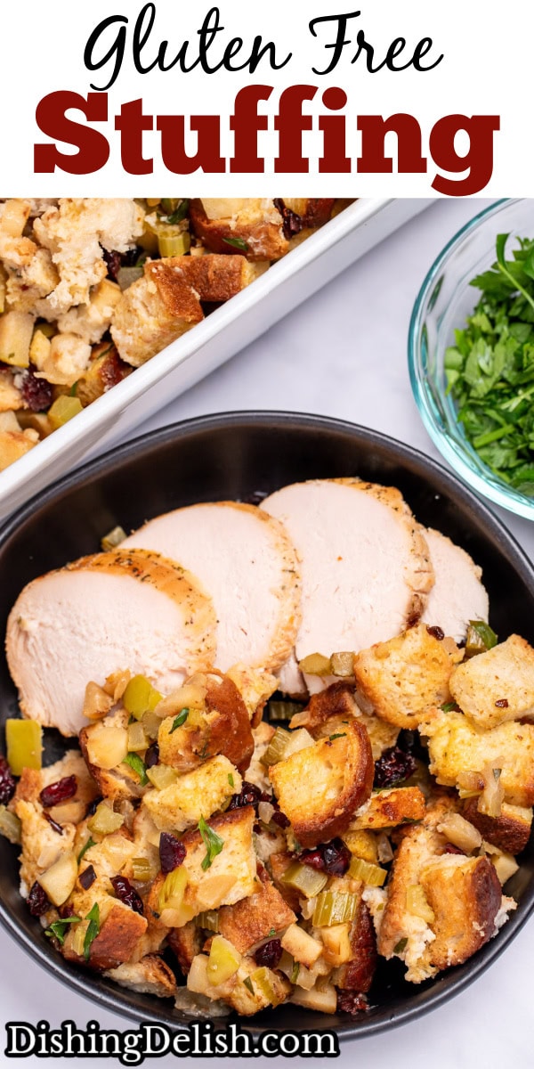A bowl with gluten free stuffing and turkey slices on a table, in front of a baking dish of stuffing, and next to a small glass bowl of chopped fresh parsley.