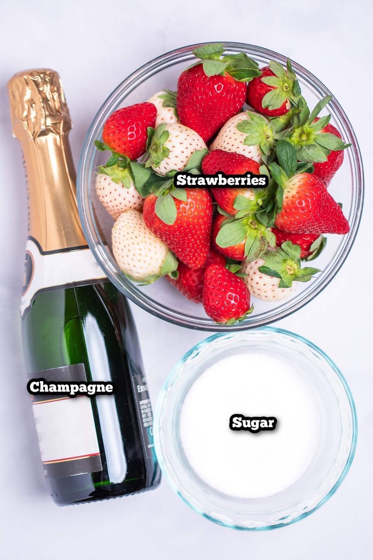 Individual ingredients for champagne strawberries on a table.