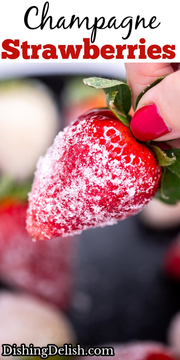 A hand holding a sugar coated champagne strawberry.