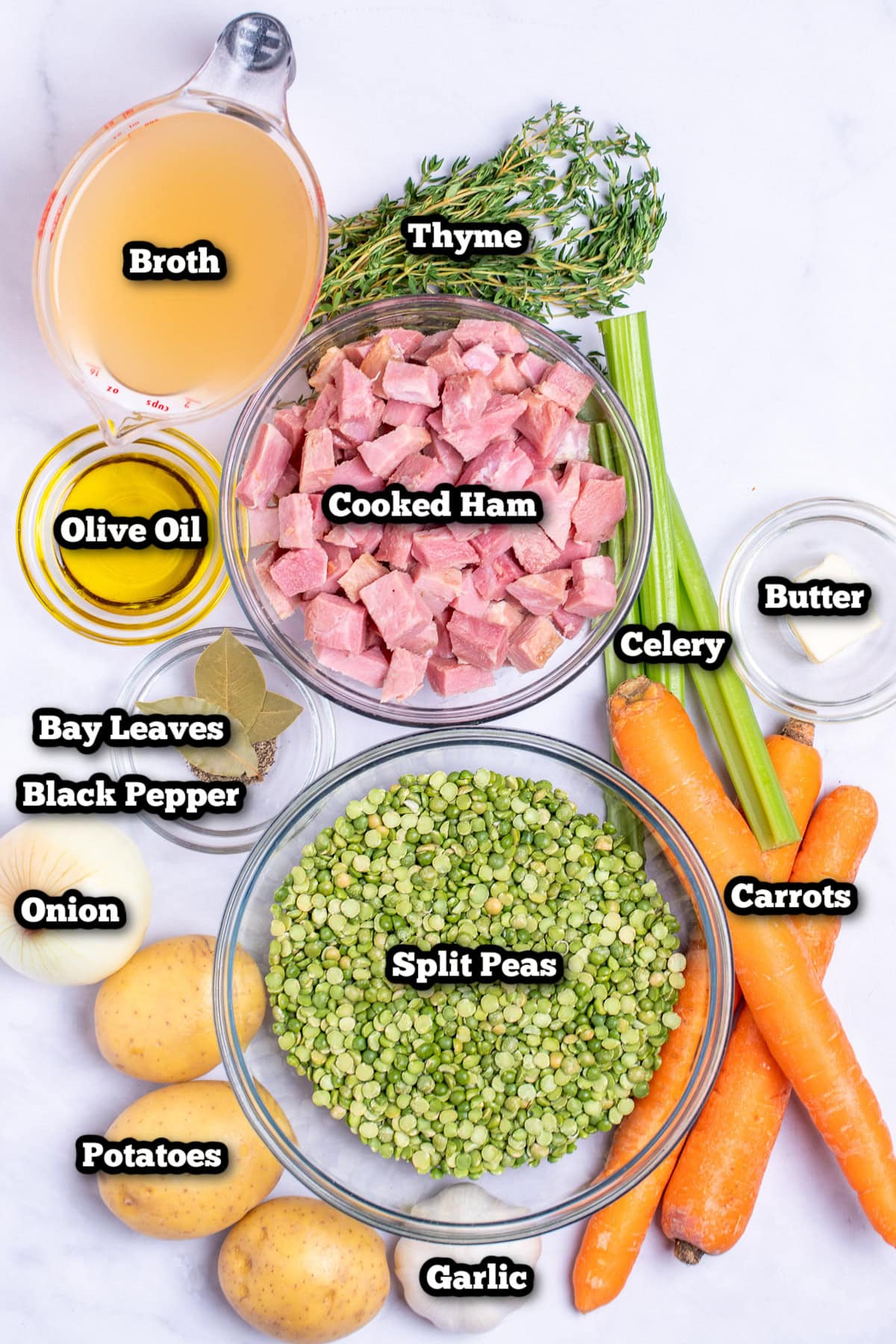 Individual ingredients for ham and split pea soup on a table.