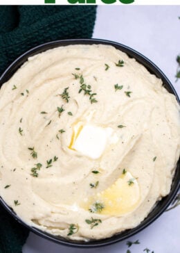 Pinterest pin with a bowl of parsnip puree topped with butter and thyme, next to a towel and fresh thyme on a table.