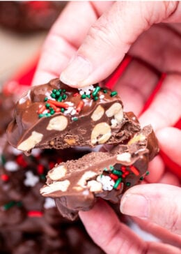 Pinterest pin with a hand holding a chocolate peanut cluster cut in half.