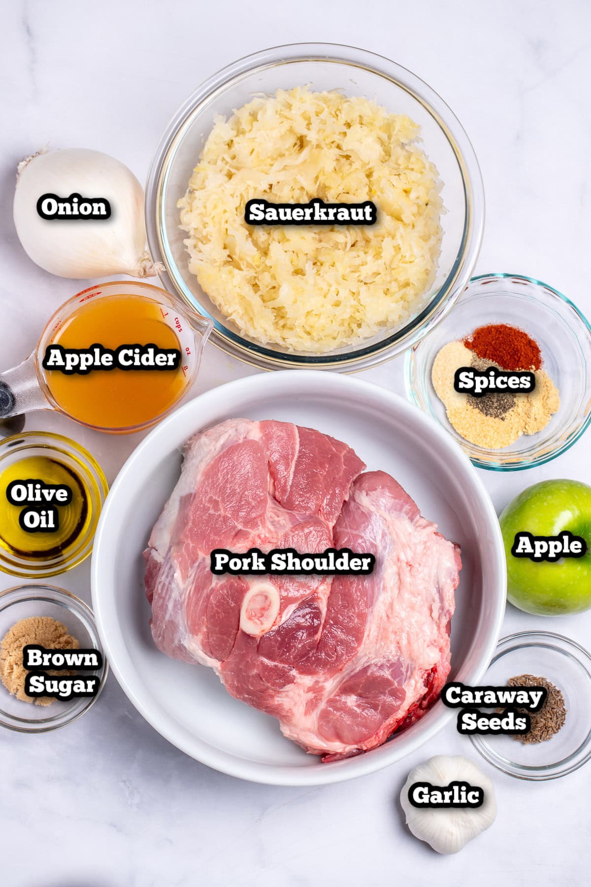 Individual ingredients for pork and sauerkraut on a table.