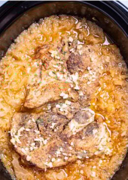 Pinterest pin with a slow cooker with cooked bone-in pork shoulder surrounded by sauerkraut and juices.