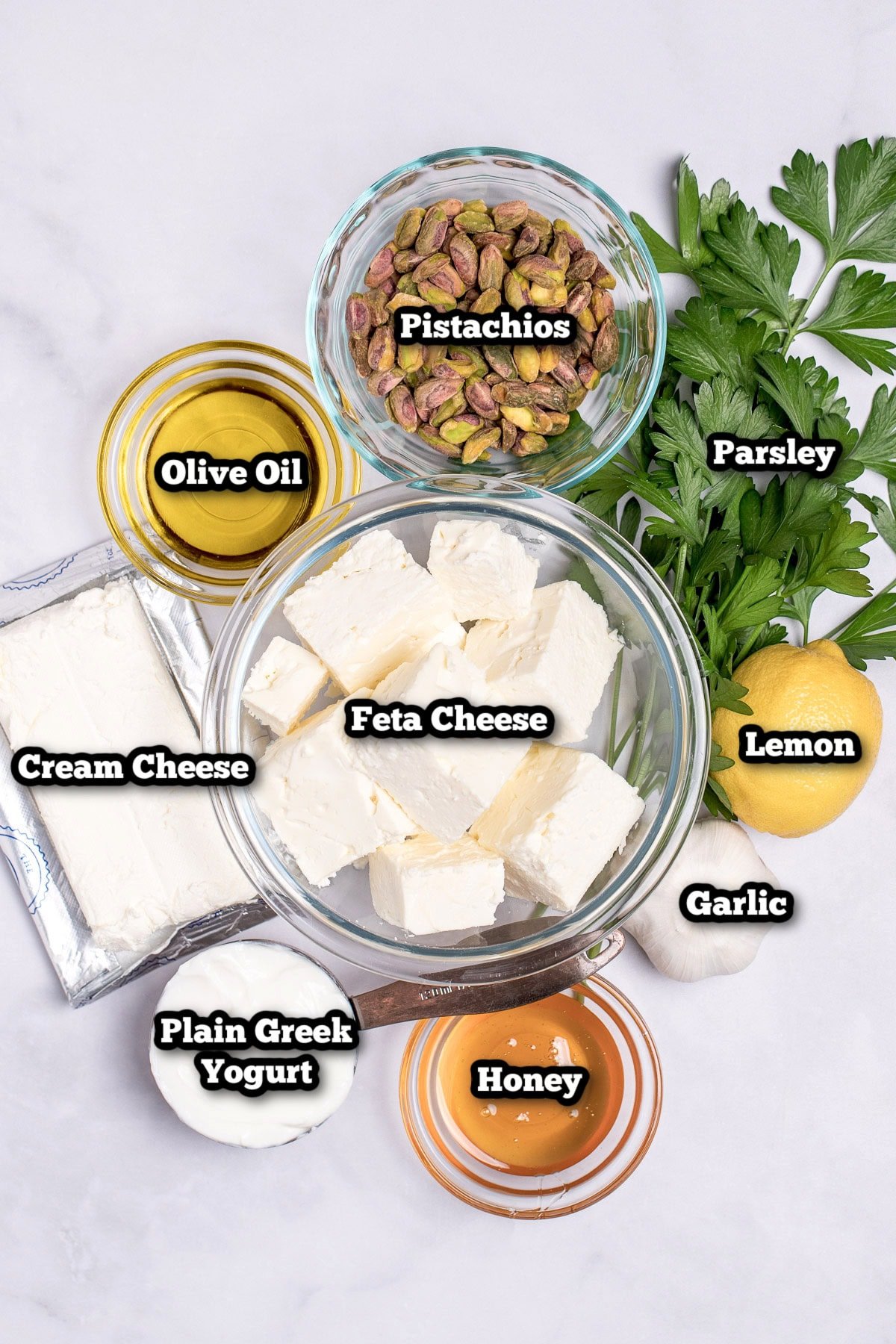 Individual ingredients for whipped feta dip on a table.