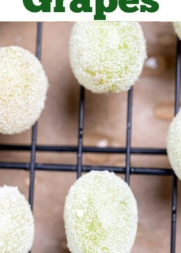 Pinterest pin with a sheet pan lined with parchment paper and a rack, with grapes rolled in sugar on top.