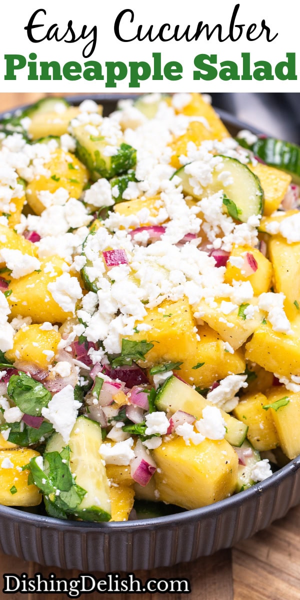 Pinterest pin with a bowl of pineapple cucumber salad topped with feta cheese sitting on a wooden cutting board.