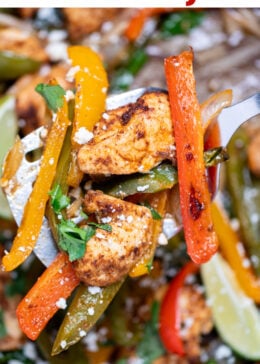 Pinterest pin with a sheet pan lined with parchment paper with cooked chicken and peppers topped with fresh cilantro, with a spatula lifting some up.