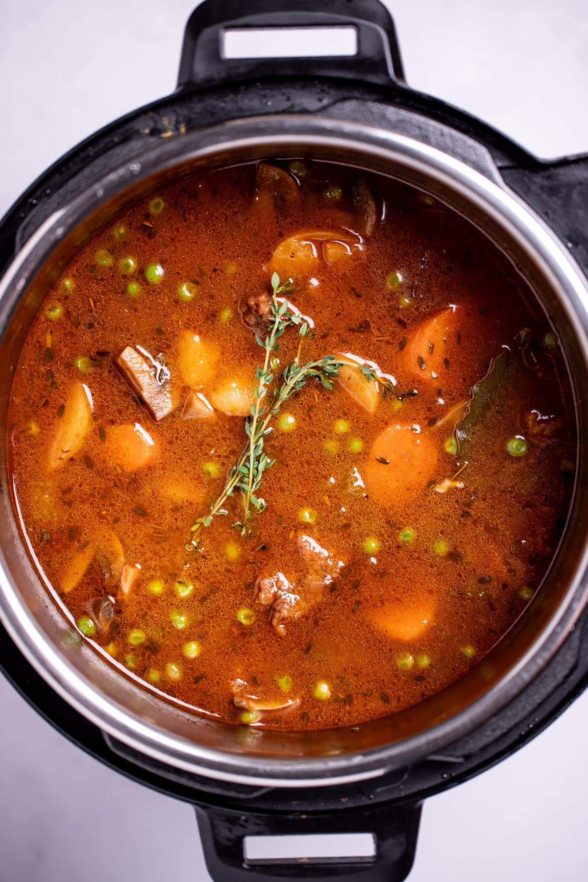 An instant pot with beef stew before being cooked.