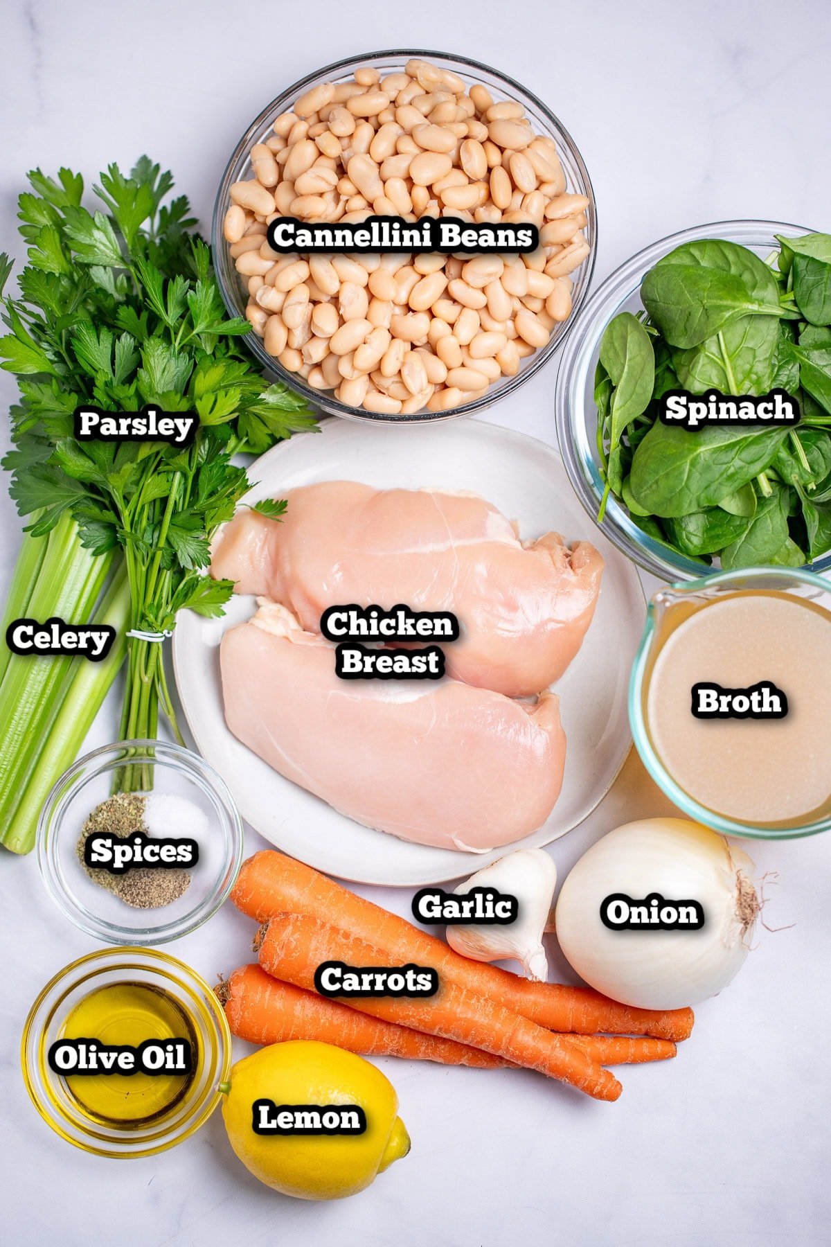 Individual ingredients for white bean chicken soup on a table.