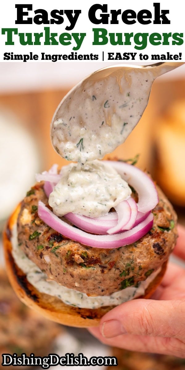 Pinterest pin with a hand holding a turkey burger with red onion, and spooning tzatziki sauce on top.