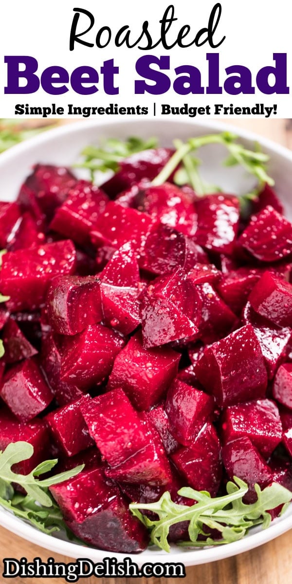 Pinterest pin with a bowl of roasted beet salad resting on arugula, on a cutting board.