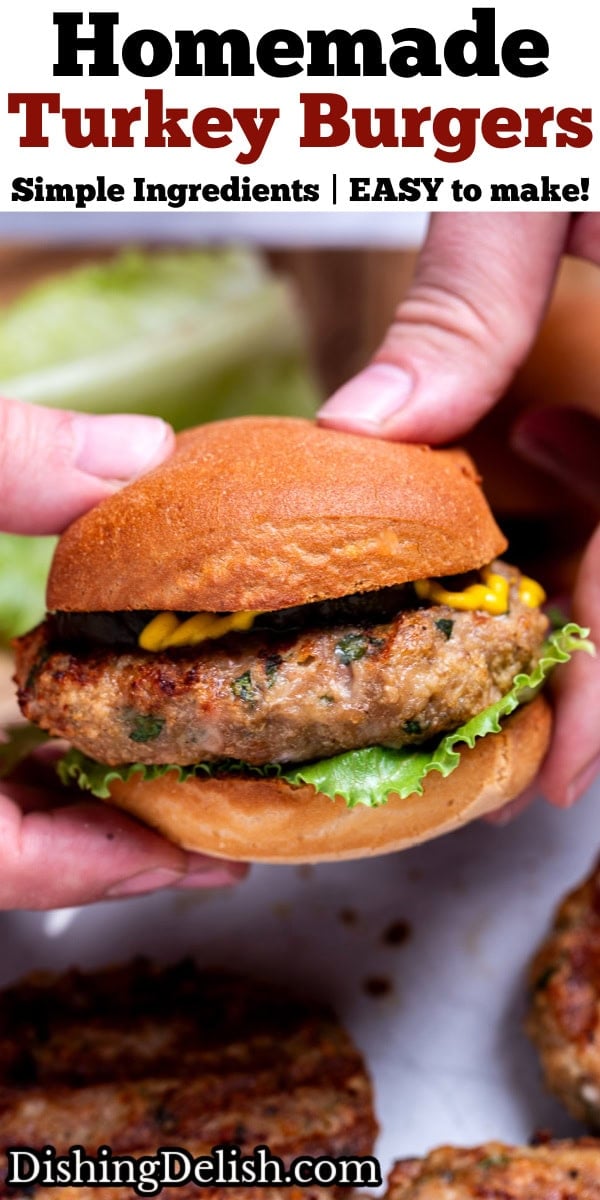 Pinterest pin with two hands holding a grilled turkey burger with lettuce, pickles, and mustard, over a plate of burger patties.