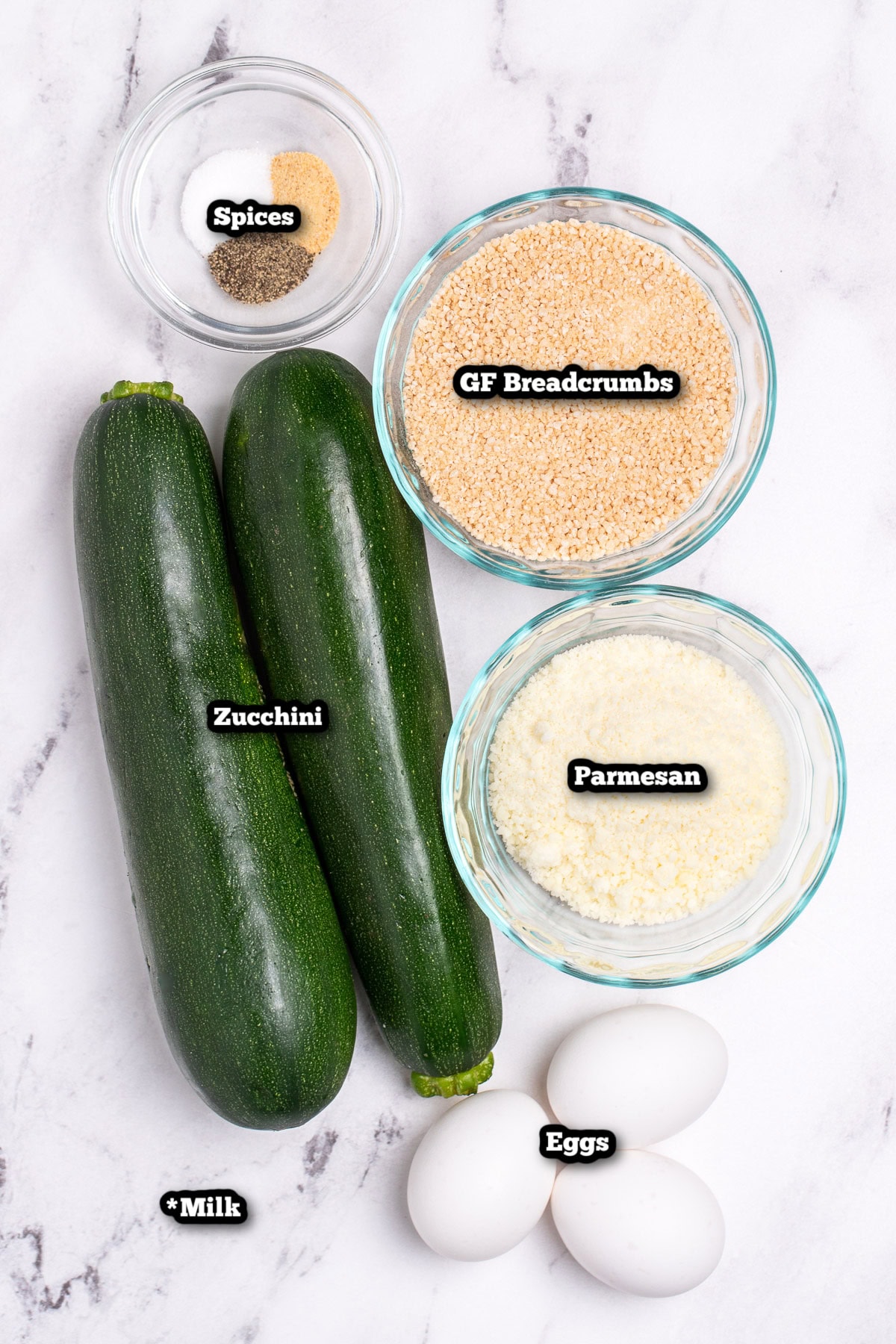 Individual ingredients for baked zucchini fries on a table.