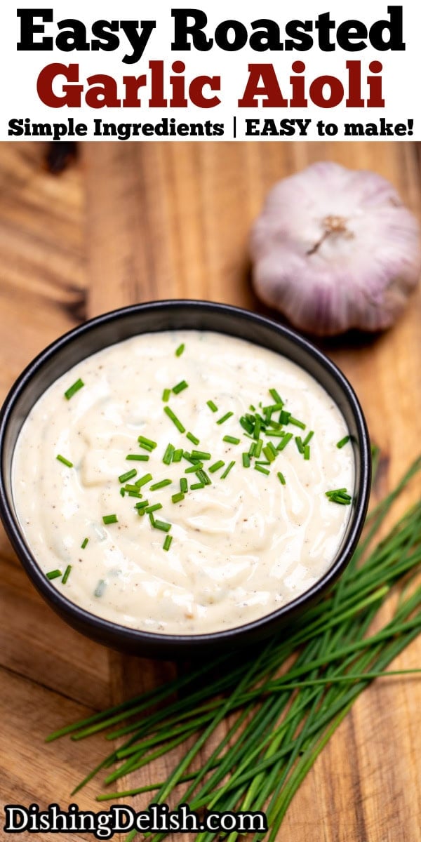Pinterest pin with a small bowl of roasted garlic aioli topped with fresh chives, on a cutting board next to more chives and a bulb of garlic.