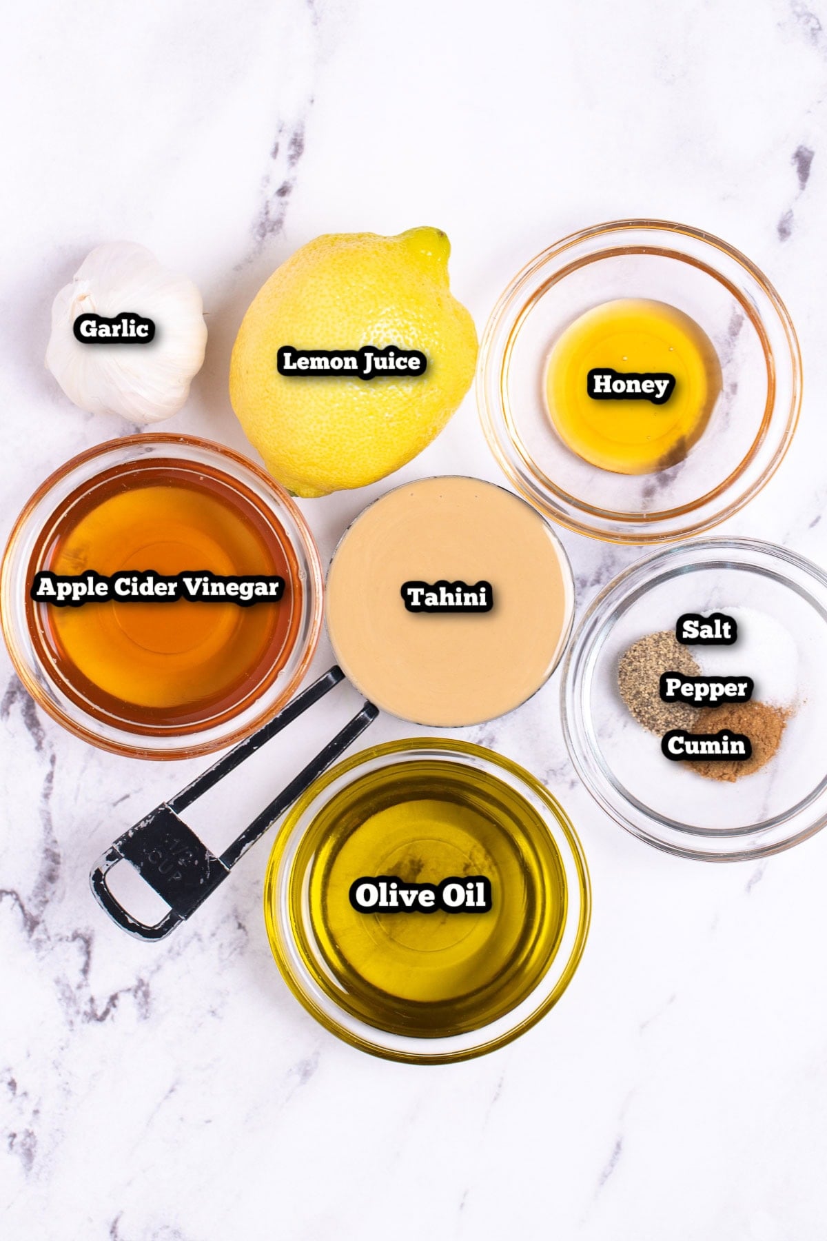 Individual ingredients for Lemon Tahini Dressing on a table.