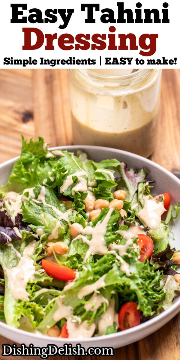 Pinterest pin with a salad with lettuce, cherry tomatoes, and chickpeas topped with lemon tahini dressing in a bowl on a cutting board, in front of a jar of dressing.