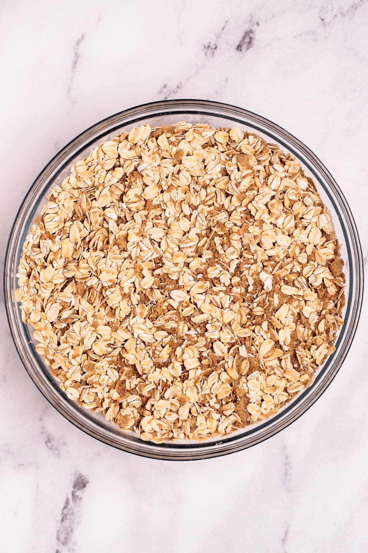 A bowl of oats mixed with brown sugar on a table.
