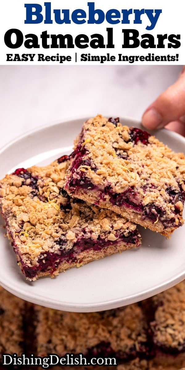 Pinterest pin with two hands holding a plate with two blueberry oatmeal bars on it, above a pan of more bars.
