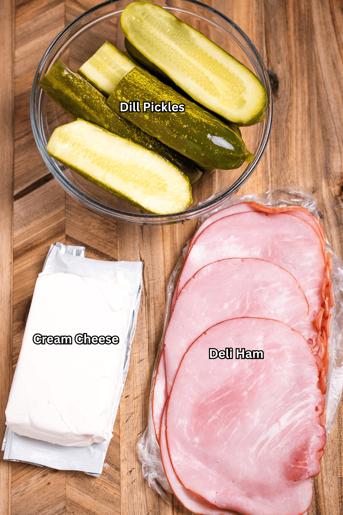 Individual ingredients for dill pickle roll ups on a cutting board.