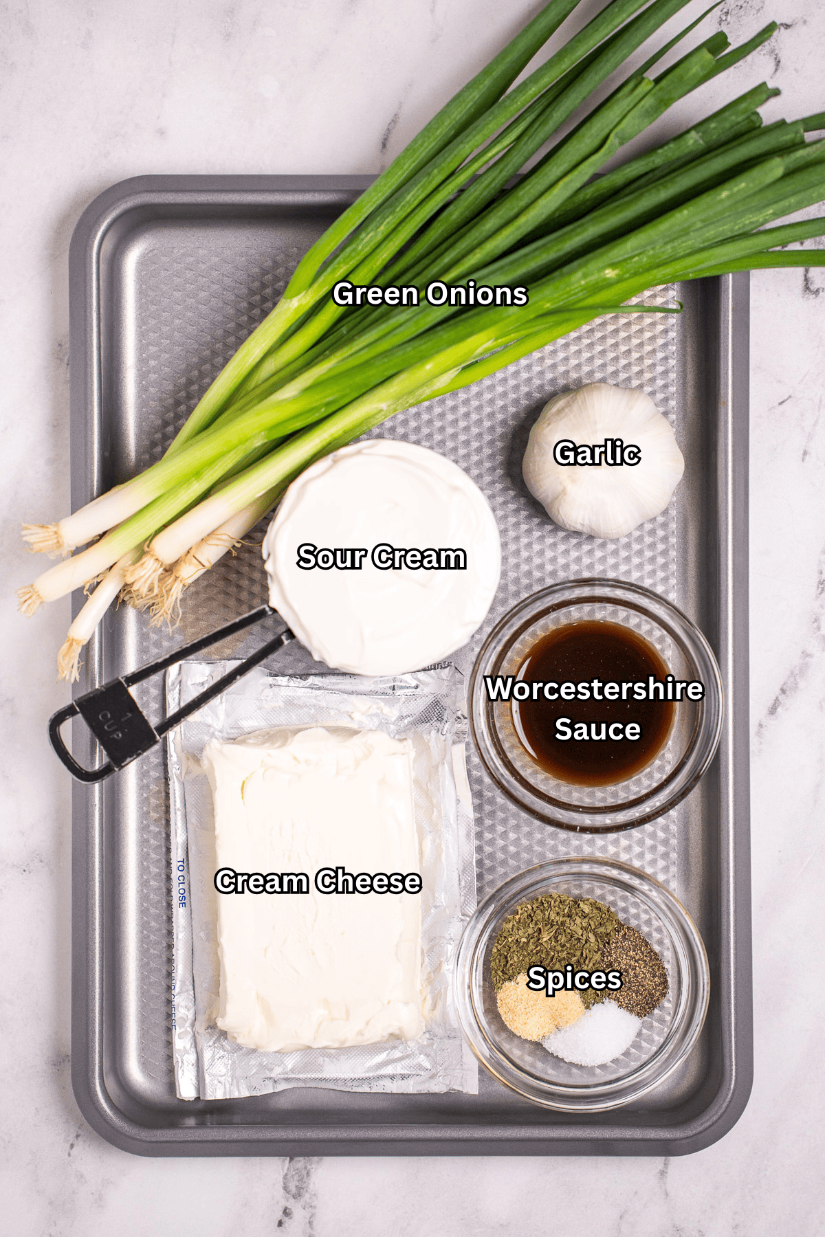 A sheet pan on a table, with individual ingredients for green onion dip.